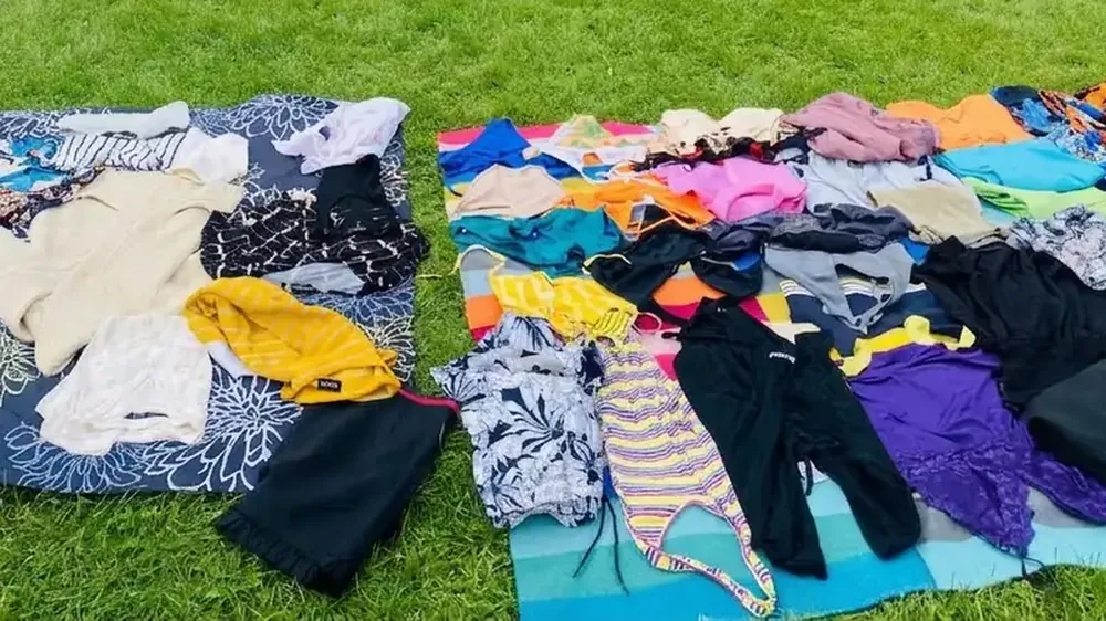 Des vêtements étalés sur des nappes au Festival du Troc, prêts à être troqués ou donnés